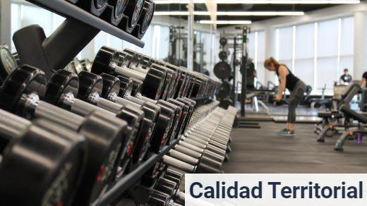woman standing surrounded by exercise equipment