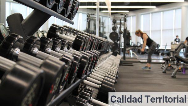 woman standing surrounded by exercise equipment