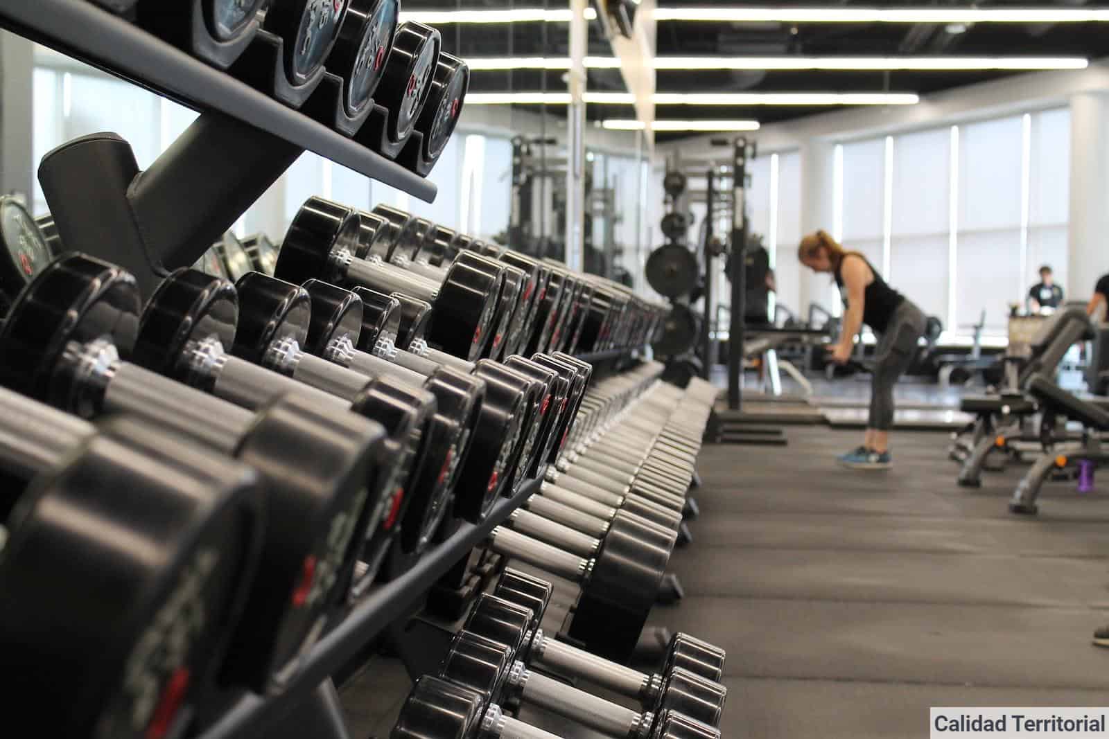 woman standing surrounded by exercise equipment